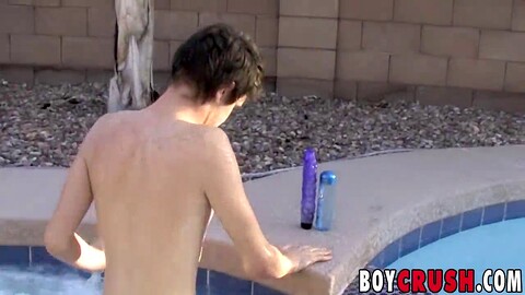 Un twink disfrutando de una sesión en solitario junto a la piscina bajo el sol