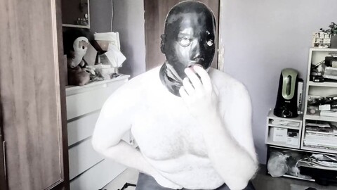 Un gars avec un masque en spandex et des tubes nasaux se masturbe et atteint l'orgasme.